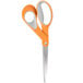 A close-up of a pair of Fiskars scissors with orange and gray Softgrip handles.