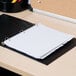 A black binder with Universal white dividers on top.