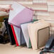 A hand holding a file folder next to a stack of folders.