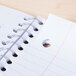 A Universal black wirebound notebook with holes in it.