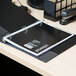 A black Universal 1 subject notebook with a spiral ring binder on a desk.