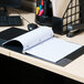 A black Universal spiral notebook on a desk.