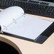 A Universal black wirebound spiral notebook on a desk.