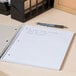 A black Universal 3 subject notebook with writing on it on a desk.