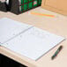 A Universal assorted color wirebound notebook on a desk with a pen
