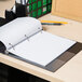 A Universal spiral notebook on a desk with a pencil.