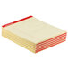 A stack of yellow lined Universal Legal Writing Pads with red lines on the top sheet.