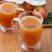 A glass mug of Cafe Delight spiced apple cider on a wooden table.