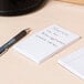 A Universal white unruled scratch pad on a table with a pen.