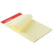 A yellow narrow ruled pad of paper with perforated edges.