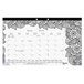 A Blueline DoodlePlan desk pad calendar with a white background and a black and white floral border.
