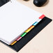 A file folder with Universal multi-color write-on dividers with colorful tabs on top.