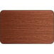 A close-up of a Lancaster Table & Seating rectangular table top with a walnut finish.