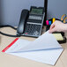 A hand writing on a Universal Legal Rule Writing Pad on a table.