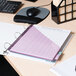 A white Universal economy non-stick view binder on a desk with a pink paper and a calculator.