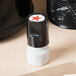 A black and white rubber stamp with a red star on it.