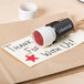 A brown envelope with a white Universal 3/4" round red pre-inked star stamp on it.