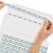 A pair of hands using Avery Index Maker dividers to organize a file folder.