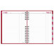 A red spiral notebook with a red stripe and white lines.