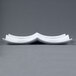 A close up of a CAC white porcelain divided tasting plate with three curved sides.