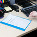 A person's hand holding a light blue leatherette report cover with a clear front and prong fasteners.