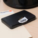 A black rectangular Avery stamp pad with a white label on it.