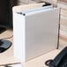 A white Universal economy view binder with papers in it sitting on a desk.
