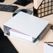 A white Universal economy view binder with a stack of papers on top of it.