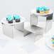 An American Metalcraft stainless steel riser set with cupcakes on them.