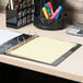 A Universal binder with a yellow paper and Universal clear extended length divider tabs.