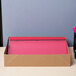 A box of 25 Universal Office red leatherette report covers with a clear cover and prong fasteners with a black pen next to it.