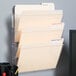 A black rectangular wall file holder with three clear pockets for letter sized files.