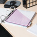 A white Universal deluxe non-stick view binder on a desk with a notebook and pen.