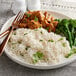 A plate of rice and meat with broccoli on the side.