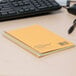 A green National wirebound notebook on a desk.