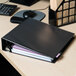 A black Universal economy non-stick view binder on a desk.