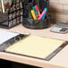 A Universal multicolored tab divider set in a yellow binder on a desk.