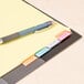 A pen on a file folder with Universal multicolored tab dividers.