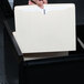 A person putting a Universal letter size file jacket into a file cabinet.