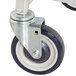 A close-up of the white and black wheel on a Winholt stainless steel platter cart.
