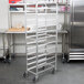A Winholt stainless steel platter cart with wheels.