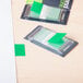 A green paper flag in a plastic dispenser.