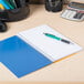 A blue National College Rule 1 Subject Notebook on a table with a pen on top.