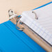 A Universal light blue non-stick view binder with papers inside.