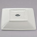 A white square Tuxton china plate with black text on it.
