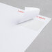 A white paper with a curled corner with a Universal White Permanent Label on it.