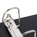 A close-up of a Universal black economy view binder with metal binder clips inside.