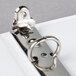 A close-up of a Universal white deluxe ring binder with metal rings.