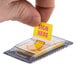 A hand holding a yellow paper with red "Sign Here" arrows.