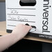 A hand opening a white Universal Economy Fiberboard Storage Box with the words "Sales Reports" on it.